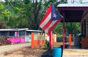 The Puerto Rican flag flying in a village affected by disaster.